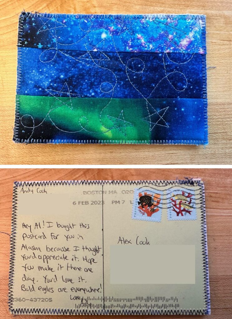 A photo showing the front and back of a cloth-covered postcard. On the front is a cool blue and green stitched cloth design, and on the back is green paper showing the stitches from the cloth on the front coming through the paper. It reads, "hey Al! I bought this postcard for you in Alaksa because I thought you'd appreciate it. I hope you make it there one day. You'd love it. Bald eagles are everywhere! Love, Andy"

On the upper-right are two ocean themed postcard stamps.